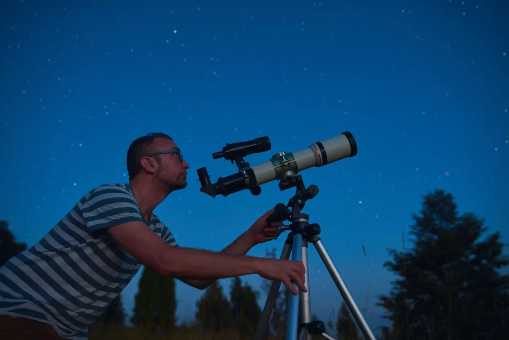 Astronóm pozoruje hviezdy ďalekohľadom