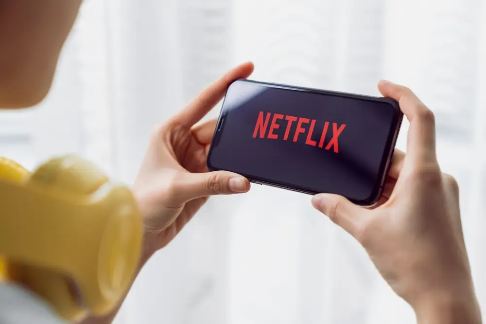 Žena sleduje Netflix na mobile