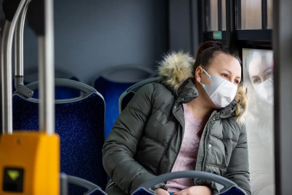 žena cestuje verejnou dopravou a nosí masku