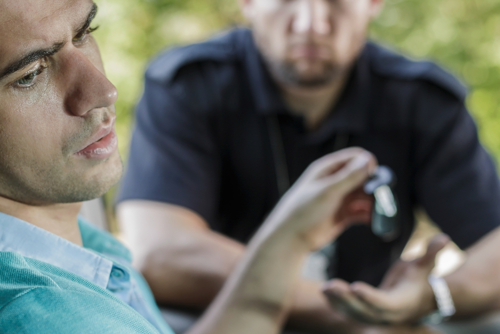 Muž odovzdá kľúče od auta policajtovi