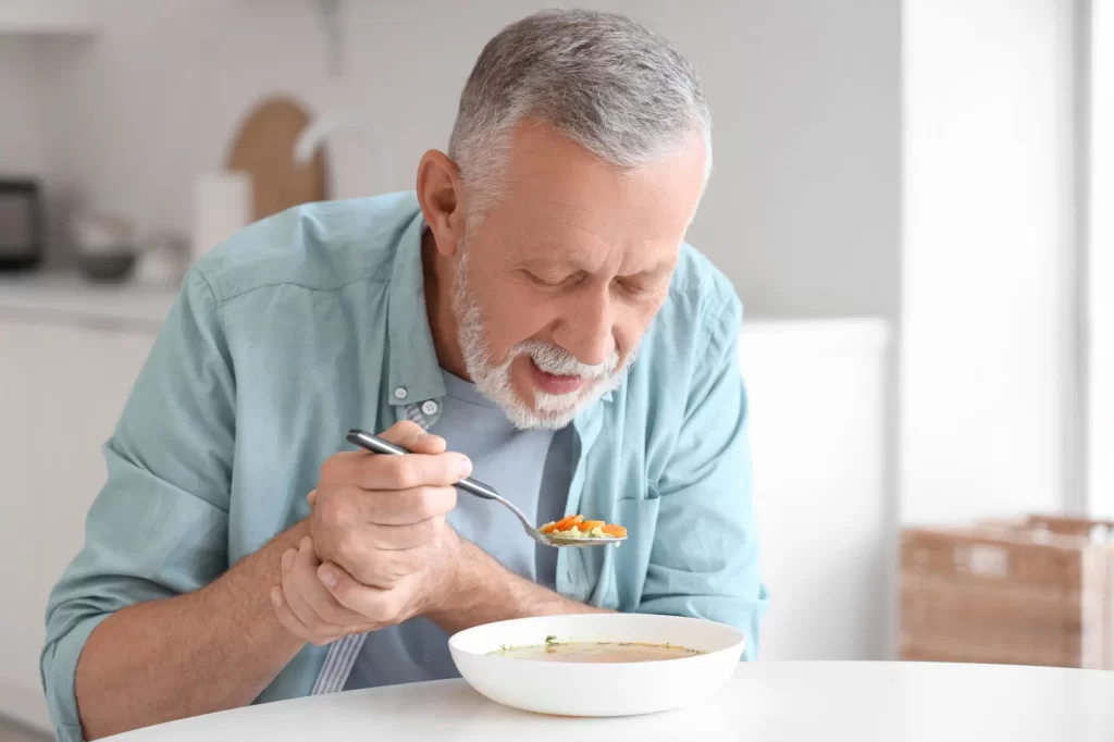 Muž s Parkinsonovou chorobou sa snaží jesť